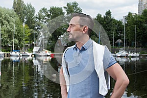 Portrait of successful man on river with sport boats. Man before river adventures in marina