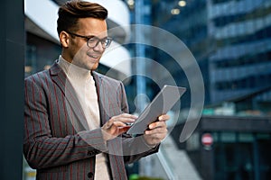 Portrait of successful man using digital tablet in urban background. Business people concept