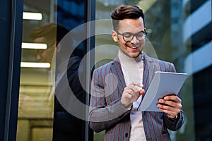 Portrait of successful man using digital tablet in urban background. Business people concept