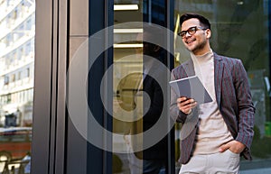 Portrait of successful man using digital tablet in urban background. Business people concept