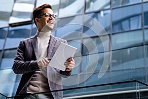 Portrait of successful man using digital tablet in urban background. Business people concept