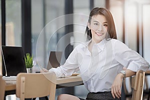 Portrait of successful middle aged businesswoman holding pen and