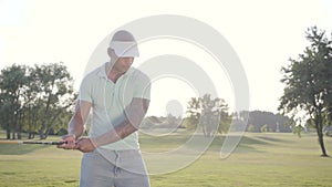 Portrait successful middle eastern golfer swinging and hitting golf ball on beautiful course. Confident man golfing in