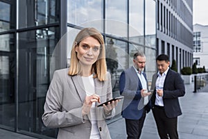 Portrait of successful senior woman businessman and specialist, program manager with tablet computer outside office