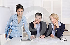 Portrait: successful smiling business team of three people; man