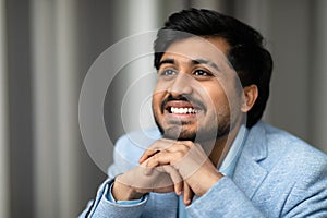 Portrait of successful smiling Middle Eastern businessman looking aside indoor