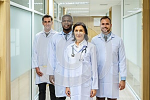 Portrait of successful team of medical doctors are looking at camera and smiling while standing in hospital