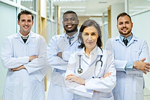 Portrait of successful team of medical doctors are looking at camera and smiling while standing in hospital