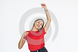 Portrait of successful winner celebrating by dancing. Beautiful young woman  on white background