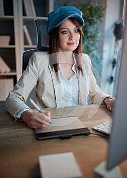 Portrait of successful woman is devoted to her career and working late on computer at office.