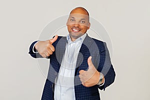 Portrait of a successful young African American guy businessman making a positive hand gesture approvingly, smiling