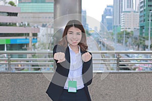 Portrait of successful young Asian business woman looking confident and smiling at urban city background.