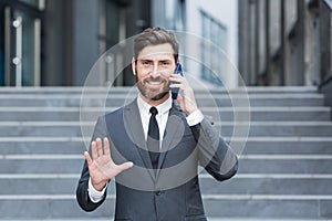 Portrait successful young confident businessman talking background urban modern office building in downtown Bearded business man