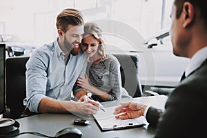 Portrait of Successful Young Couple Buying Car photo