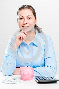 Portrait of a successful young woman with a piggy bank