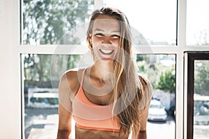 Portrait of sunburn fit woman wearing sportwear in sunny white gym photo