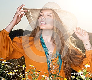 Portrait in the sunlight. Young beautiful woman posing in a field. Stylish look