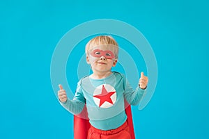 Portrait of superhero child against blue background