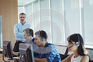 Portrait of supervisor with business team working at call center