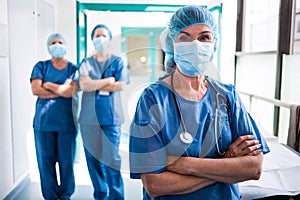Portrait of surgeon and nurses standing with arms crossed