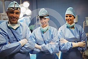 Portrait of surgeon and nurses standing with arms crossed in operation room