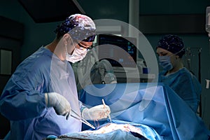 Portrait of a surgeon in the operating room against the background of a lamp, the doctor performs an operation, the