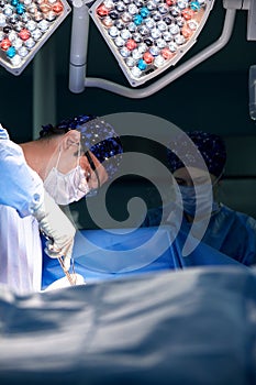 Portrait of a surgeon in the operating room against the background of a lamp, the doctor performs an operation, the