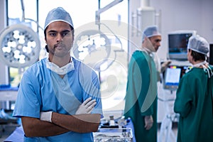 Portrait of surgeon standing with arms crossed in operation room