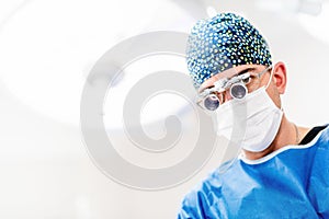 Portrait of surgeon wearing surgery loupes or goggles. Surgery in operating room at private hospital