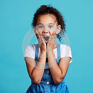 Portrait, surprise and girl with wow, facial expression and happiness against a blue studio background. Face, female