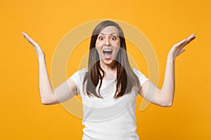 Portrait of surprised amazed young woman in casual clothes keeping mouth open, spreading, pointing hands aside isolated