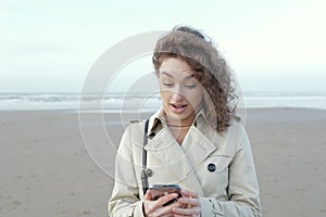 portrait of a surprised, anxious young woman looking at a phone seeing bad news or photo