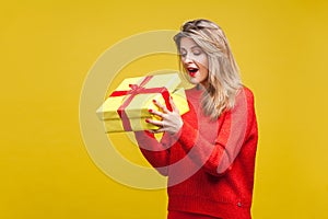 Portrait of surprised beautiful blonde woman with red listick in bright casual sweater, isolated on yellow background