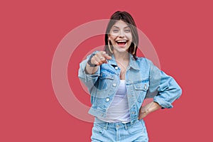 Portrait of surprised beautiful brunette young woman with makeup in denim casual style standing pointing and looking at camera