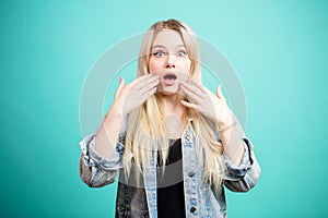 Portrait of surprised blonde woman in denim jacket