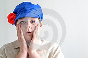 Portrait of surprised boy teenager in Russian national cap with cloves photo