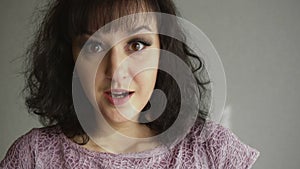 Portrait of a surprised brunette girl with long false lashes and brown eyes. Cute female model with fashionable makeup