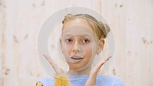 Portrait surprised girl with opened mouth and eyes looking to camera on light background in studio. Shocked teenager