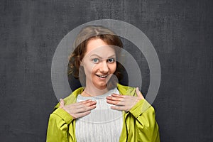 Portrait of surprised girl pointing to herself