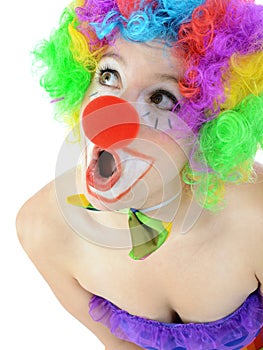 Portrait of a surprised looking clown with wig and red nose in studio