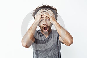 Portrait of surprised and shocked african man with opened mouth finding out he missed a sale or is late to work or