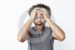 Portrait of surprised and sleepy african man with opened mouth against white wall. Forgot to take a kettle off his stove