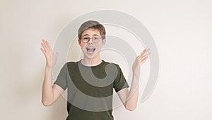 Portrait of surprised teen boy in eyeglasses on white background. Funny boy looking at camera in shock or amazement. Handsome