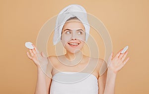Portrait of surprised woman after bath. Beauty face of a cheerful attractive girl with towel on head, isolated