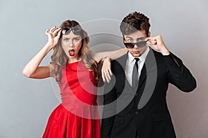 Portrait of a surprised young couple dressed in formal wear