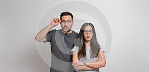 Portrait of surprised young couple with mouth open looking at camera and posing against isolated background. Amazed man and woman