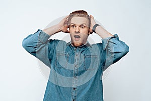 Portrait of Surprised Young Man Holding Hands Head