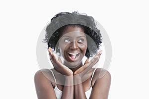 Portrait of a surprised young woman shouting over white background