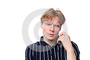 portrait of suspicious handsome european 25s blond man in blue polo