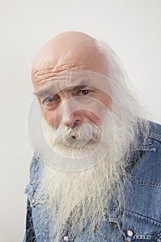 Portrait of suspicious senior man over gray background